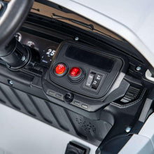 Close-up of Ford ride-on truck dashboard controls with red buttons and screen