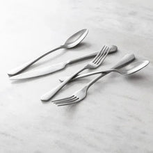 Antiqued flatware set of spoon and fork, satin silver, angled on table