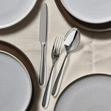 Stainless steel fork and spoon on a place mat