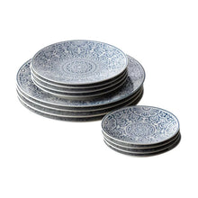 Blue and white patterned dinner plates stacked, featuring circular floral centerpiece