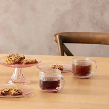 Clear textured glass coffee cups with handles, three on table