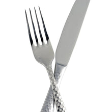 Faceted flatware fork and spoon overlapping, polished silver with textured grip
