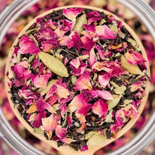 Close-up of loose leaf chai blend with dried pink petals and green spice pieces