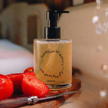 Pump soap bottle with amber liquid and Fountain of Waters label