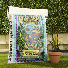 FoxFarm potting soil bag on grass with nearby plant pot