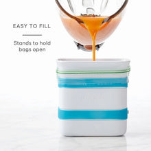 Freezer food block maker mold with teal band as orange liquid pours from funnel