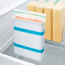 Freezer food block maker mold with teal band holding orange food blocks in freezer tray