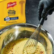 French's Classic Yellow Mustard pouch beside whisk and metal mixing bowl