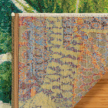 Indoor/outdoor rug edge close-up with woven multicolor texture and leaf motif.