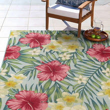 Indoor/outdoor rug with large hibiscus flowers and green leaves, pink and yellow on light blue