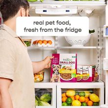 Person placing small dog dog food bags in a refrigerator.