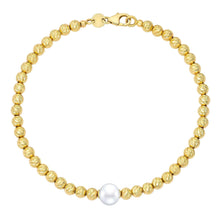 Freshwater pearl bracelet with gold clasp and central white pearl on cream-gold bead strands