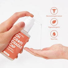 Cradle cap treatment bottle dispensing into open hand, with label icons