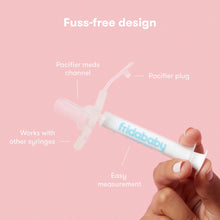 Hand holding clear baby medicine dispenser syringe with pacifier tip