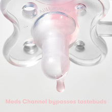 Close-up of clear pacifier medicine dispenser tip with liquid flow