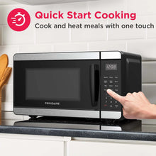 Black countertop microwave oven with digital keypad and handle, front view