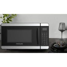 Black countertop microwave oven with digital keypad and LED display, door closed