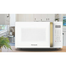 Countertop microwave with white front, gold handle, and control keypad with display
