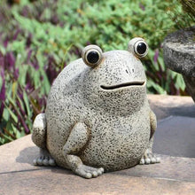 Light gray frog garden statue with bulging eyes and smiling mouth, sitting on a rock