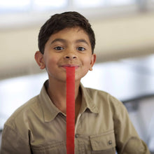 Fruit strip snack held by a smiling child in a beige shirt