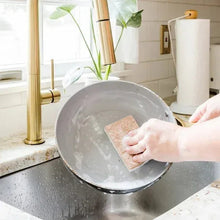 Walnut non-scratch sponge pad scrubbing a metal pan in the sink