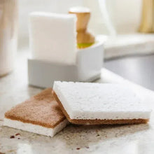 Walnut non-scratch sponge pads with white scrub layer on a countertop