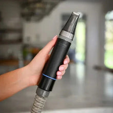 Hand holding black vacuum attachment with clear nozzle top and blue ring