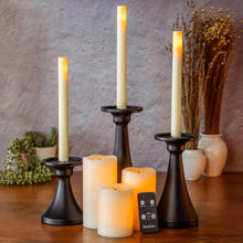 Black candle holder set with taper candles and a small remote controller