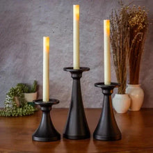 Set of matte black candle holders with taper candles, tabletop arrangement