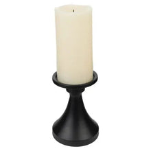 Matte black candle holder with a cream taper candle on top