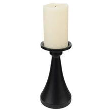 Tall matte black candle holder with a cream taper candle, close-up