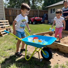 Kids metal wheelbarrow with blue tub and green frame on grass outdoors