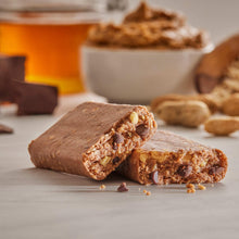 Peanut butter protein bar with visible filling, broken pieces on a light surface