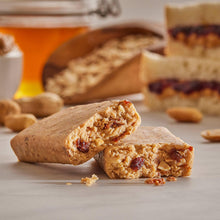 Chocolate chip protein bar, broken bar pieces with visible dark bits on a light surface