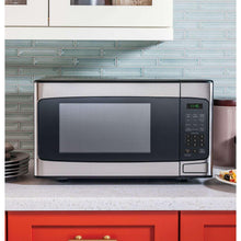 GE countertop microwave oven with black glass door, control panel, and stainless frame