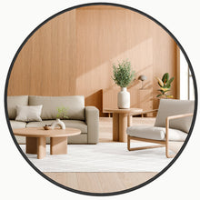 Round bathroom vanity mirror with black frame, circular glass reflecting seating area
