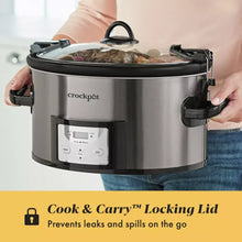 Stainless steel slow cooker being carried with locking lid and control panel
