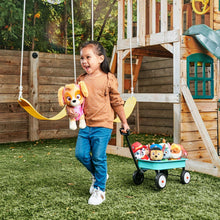 Plush dog toy set in a wagon with a child holding one plush