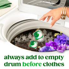 Laundry detergent pacs in washing machine drum with purple flowers