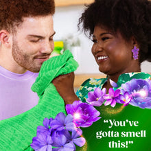 Laundry detergent pacs concept with green cleaning cloth and purple flowers