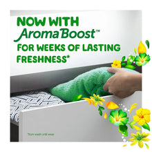 Hand on a green towel on striped bedding with AromaBoost freshness text