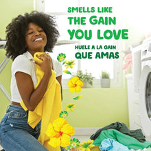 Gain powder laundry detergent box with bright yellow flower graphics shown near a washer