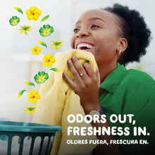 Gain powder laundry detergent box with yellow flower graphics, shown beside a person