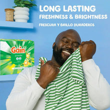 Gain powder laundry detergent box shown near a person, green with floral freshness graphics