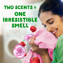 Person holding pink shirt with cherry and rose icons, for in-wash scent booster