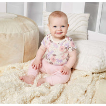 Newborn baby in floral cotton short-sleeve romper with solid pink legs