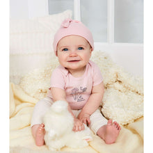 Newborn baby wearing pink cotton bodysuit with knot hat and small flower graphic