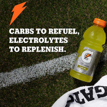 Sports drink bottle, green lemon line flavor, orange cap on grass