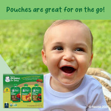 Baby food pouch variety pack beside a smiling baby