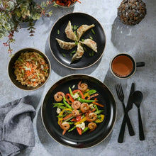 Gibson Home round dinnerware set—black bowls with plated food and a mug